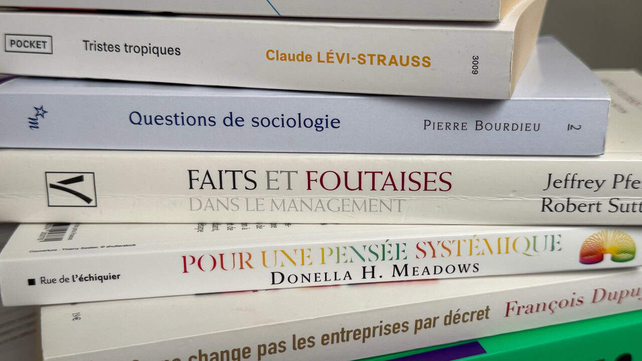 Sciences sociales entreprise – pile de livres de sociologie des organisations et pensée systémique